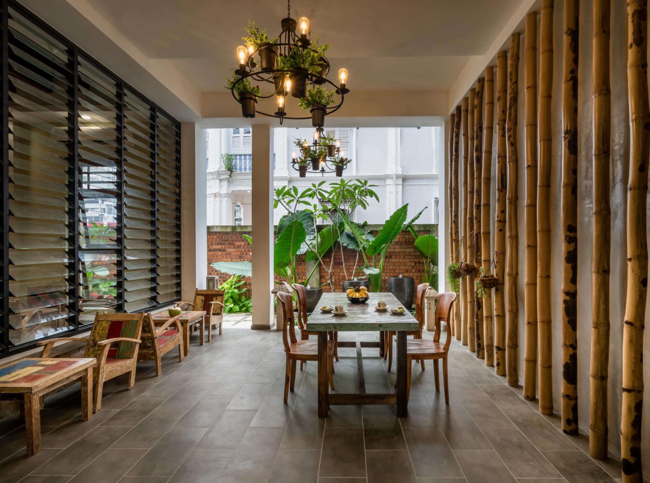 The bamboo-lined lobby of Treasures Hotel with heritage chandelier and tropical plants